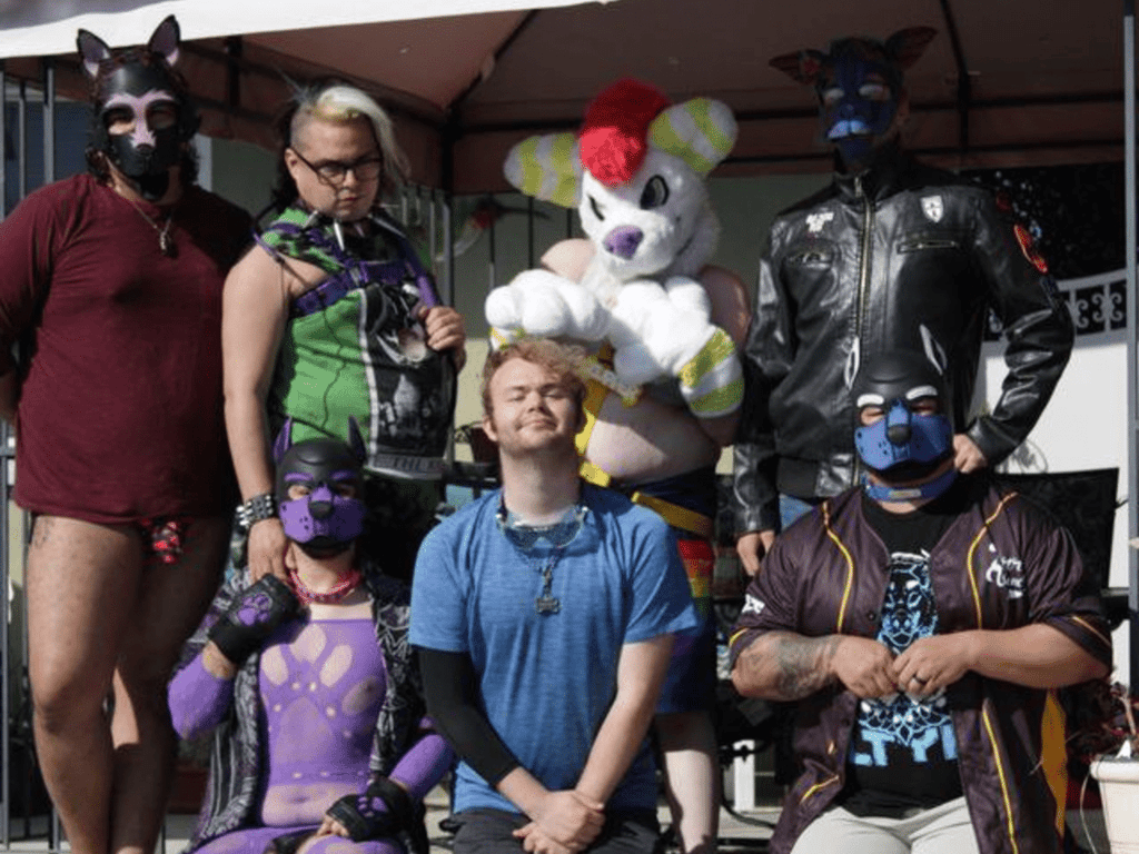 Group photo of people in pup and furry masks and costumes.