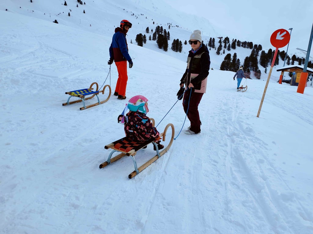a woman is pulling a sled with a child in a sled