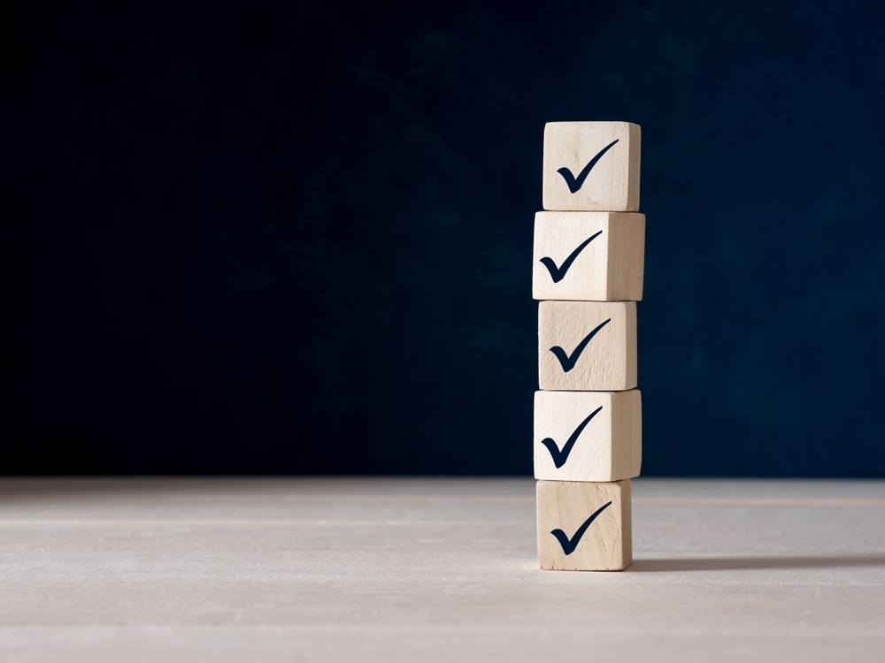 A stack of wooden blocks with tick check marks on them