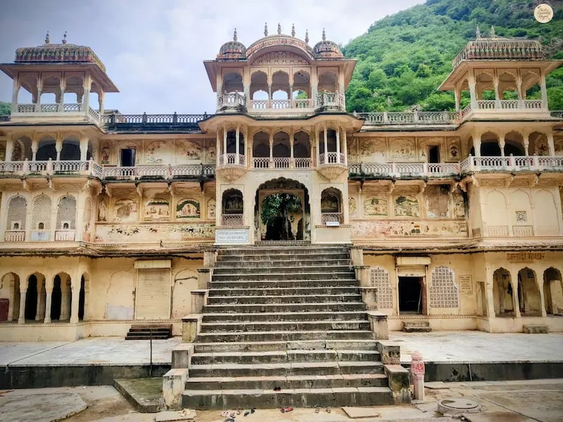 See the elegant Rajput-style temple architecture at Galta Ji Temple complex in Jaipur, surrounded by the Aravalli hills.