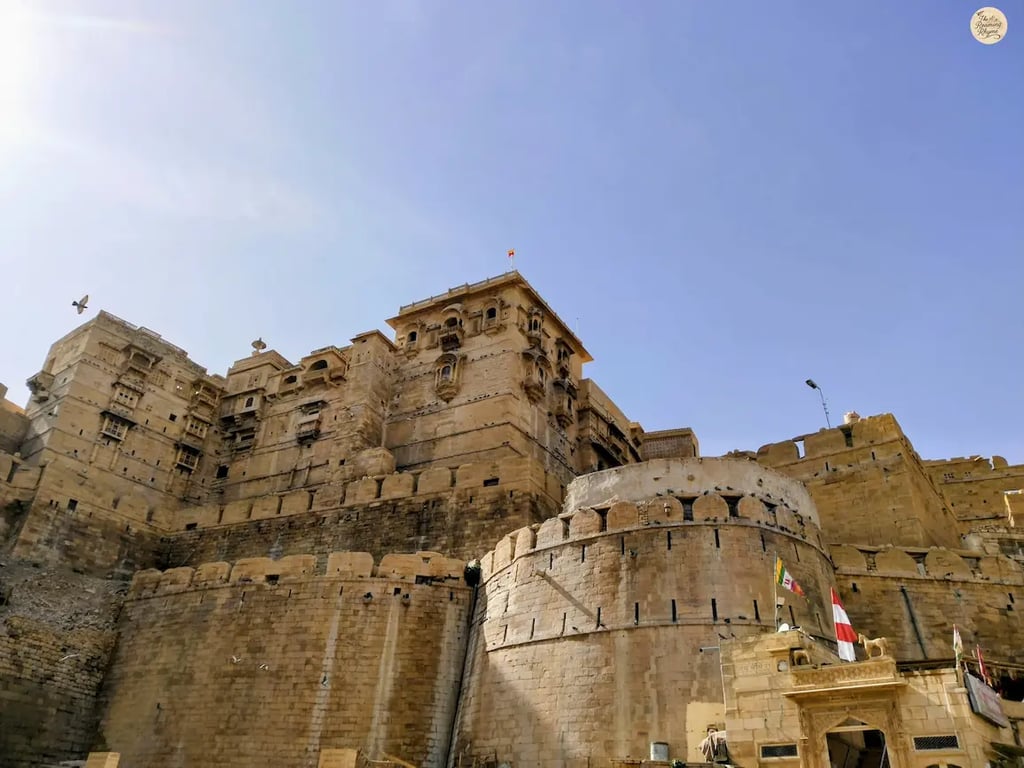 Jaisalmer Fort glowing in golden sandstone under bright sunlight.