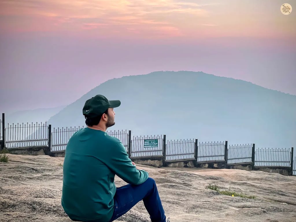 Orange, pink, and reddish sky during sunrise from the rocky terrain of Tipu’s Drop at Nandi Hills, Karnataka