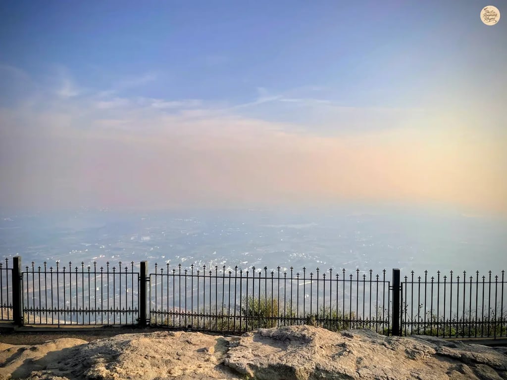 Beautiful sunset at the horizon as seen from Nandi Hills near Bengaluru, casting golden light over misty valleys and hilltops