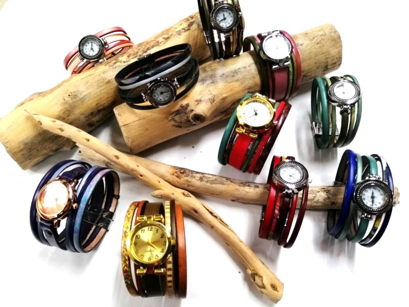 a bunch of bracelets and watches on a stick