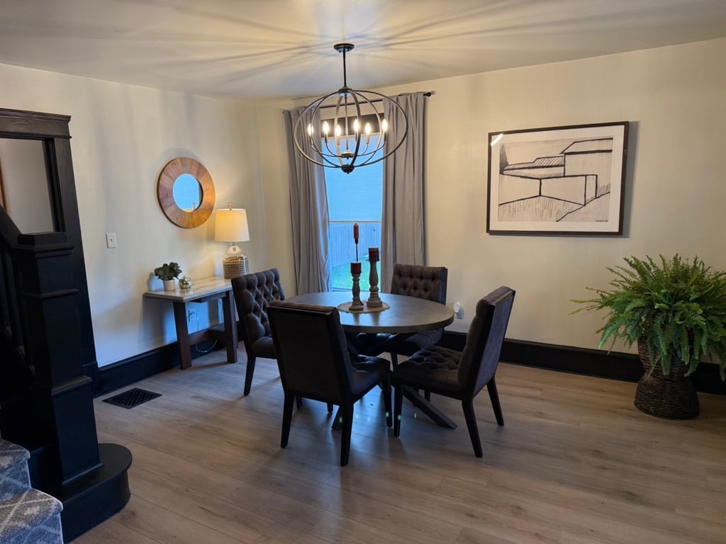 Ohio staged Modern dining room featuring a round wooden table, and a metal orb chandelier.