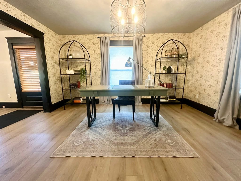 Ohio staged Modern home office with a vintage rug, floral wallpaper, and metal arched bookshelves.