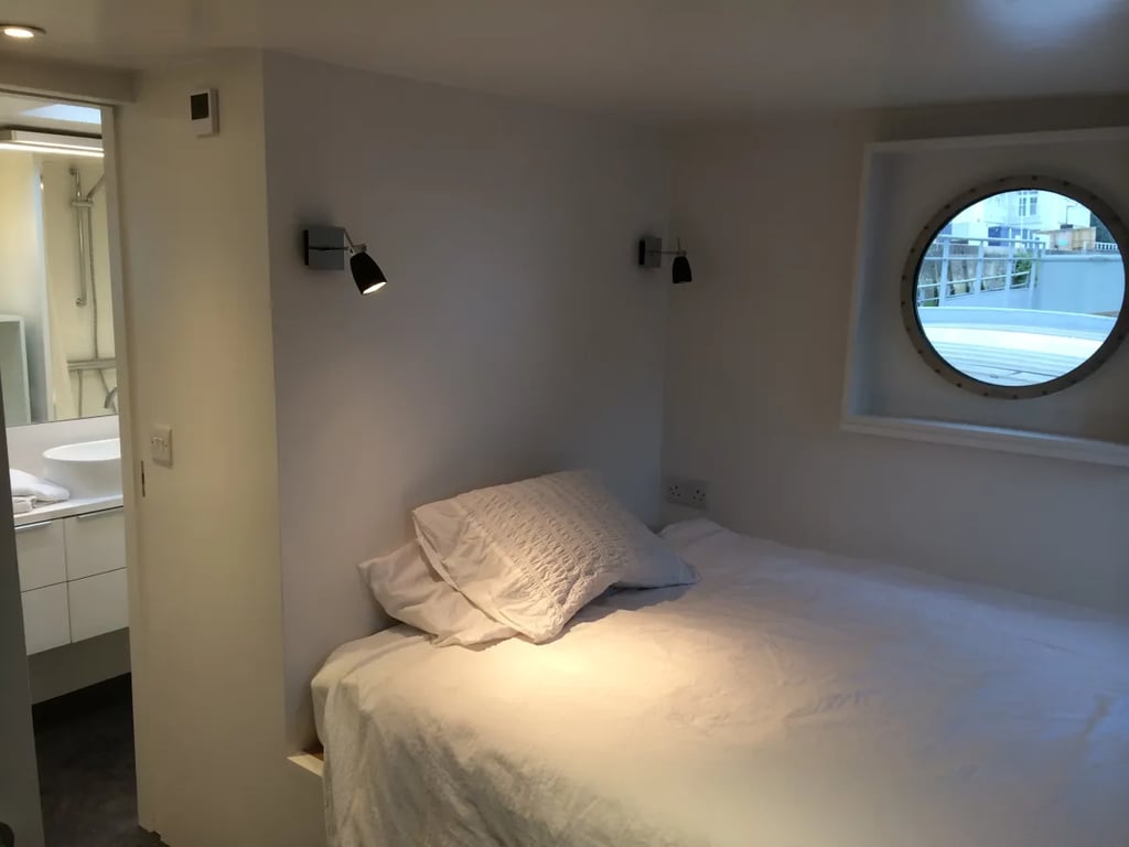 slaapkamer op een binnenschip met een ronde patrijspoort.