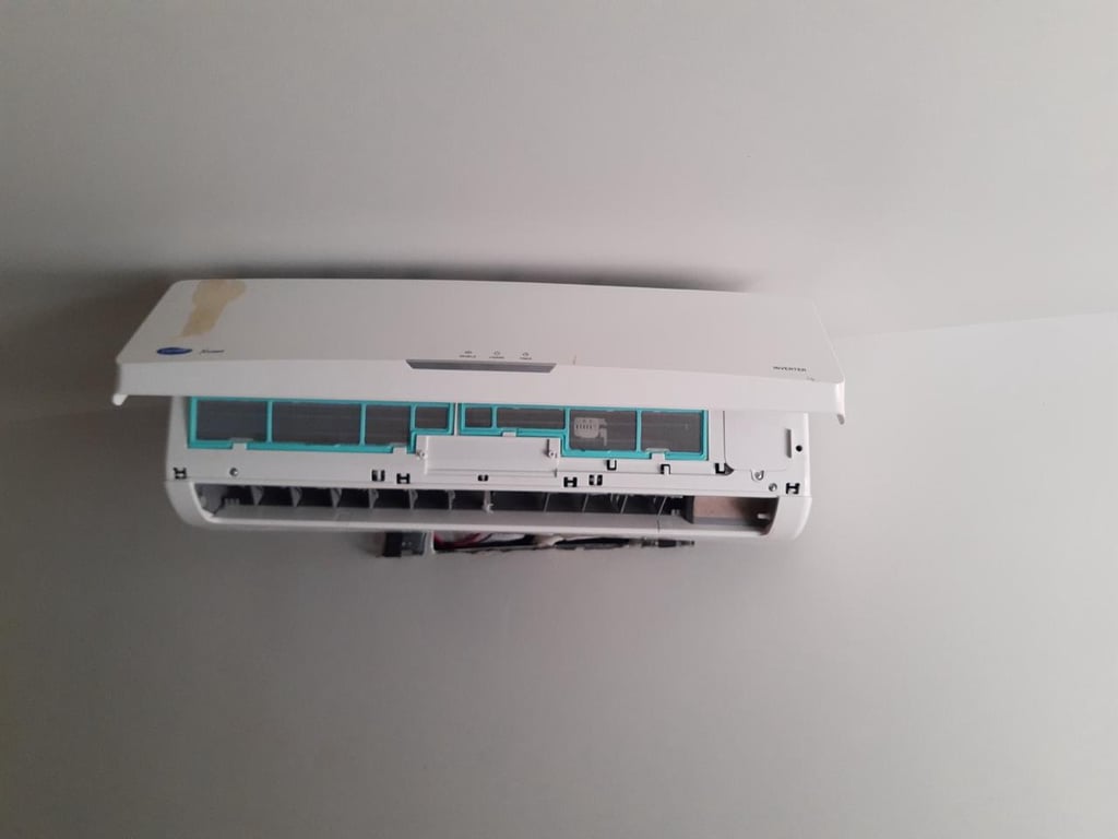 A wall-mounted Carrier split air conditioner unit with its front cover open for filter cleaning or repair.