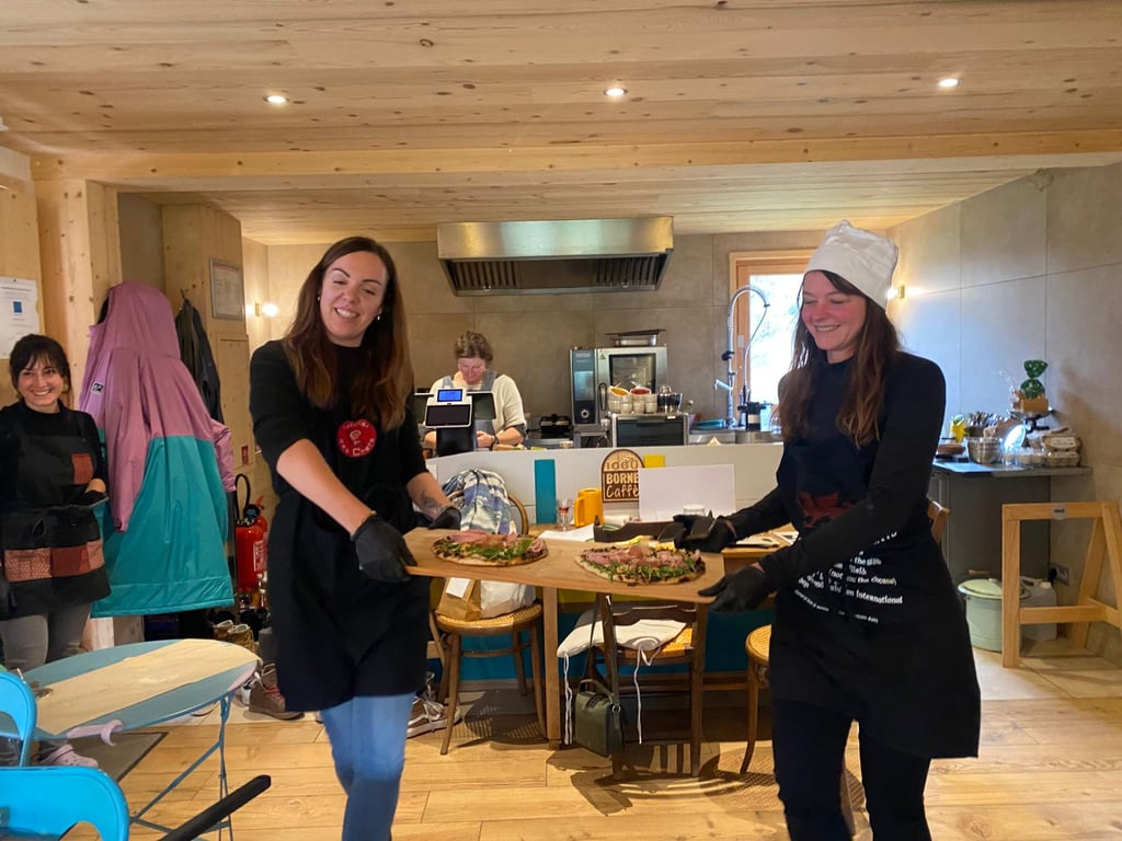 Smiling team of collegues serving fresh artisanal pizza on wooden boards in a cozy restaurant.