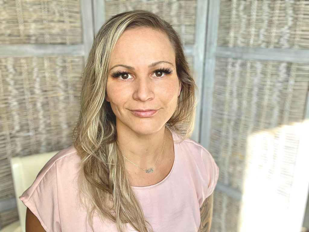 a woman with blonde hair and a pink shirt