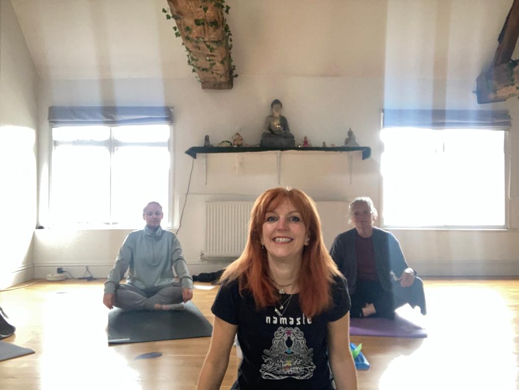 Yoga teacher Katie sat with her students smiling