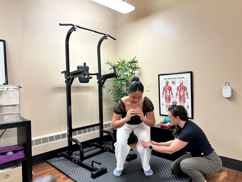 Chiropractor correcting patient's knee position in a squat.