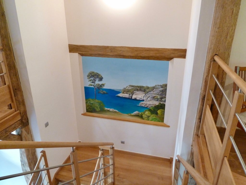 Fresque murale dans une cage d'escalier, ouverture en trompe-l'oeil sur un paysage de bord de mer