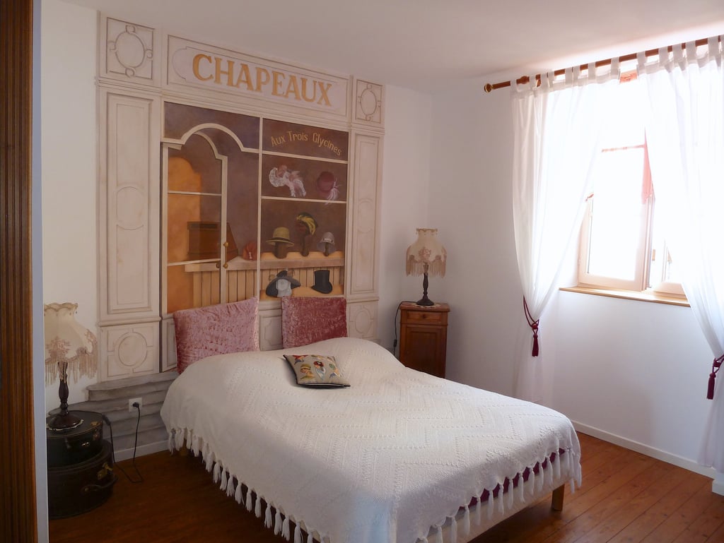 Chambre d'hôtes thème les chapeaux anciens, fresque peinte sur un mur intérieur en tête de lit