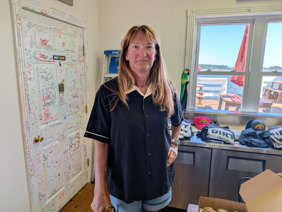 Ellen standing in front of a table with t-shirts on it