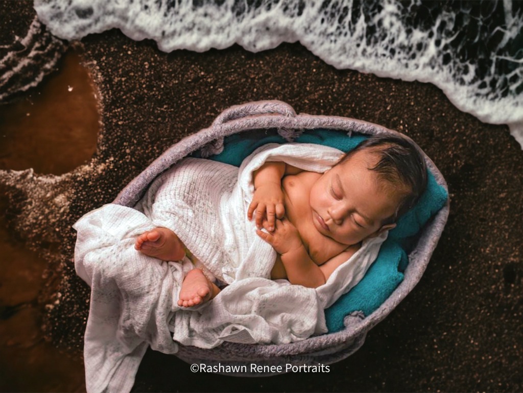 a baby boy is sleeping in a basket with his head on a blanket at thte beach