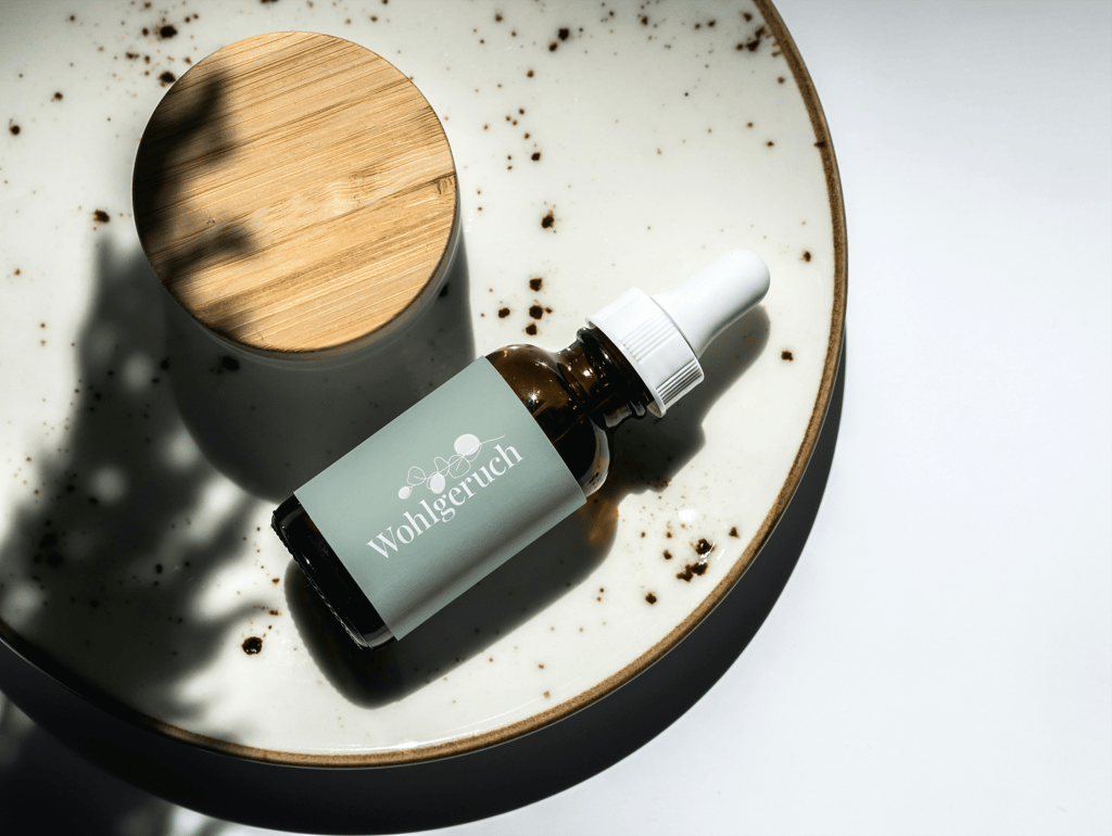 Eine Pipettenflasche aus Braunglasauf einem Keramikteller mit natürlichen Schatten.