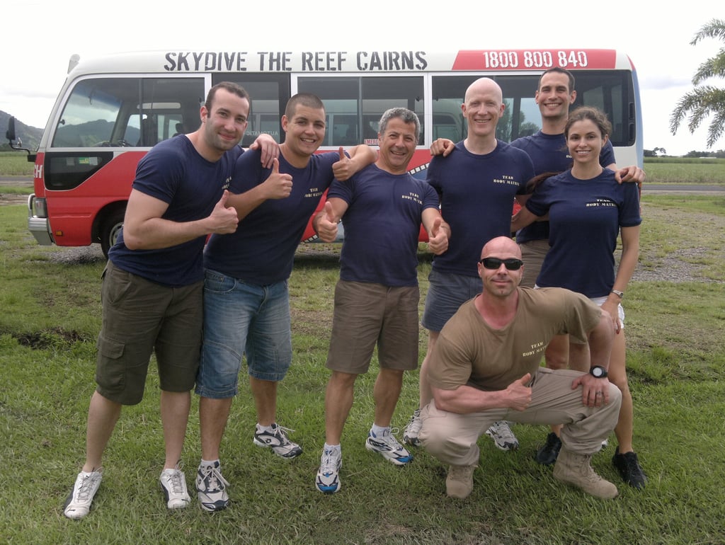 a group of adventure seekers standing in front of a bus