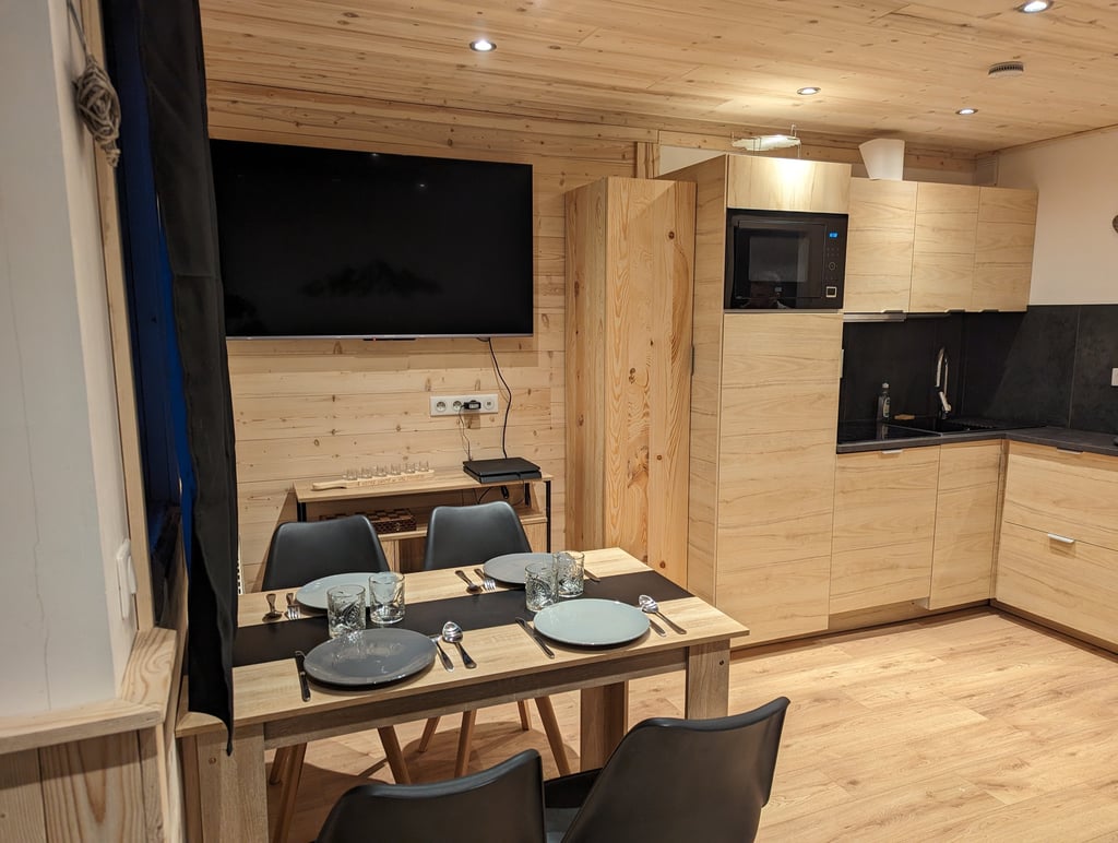 Open alpine living area with kitchen and dining space in a cozy ski-in ski-out apartment