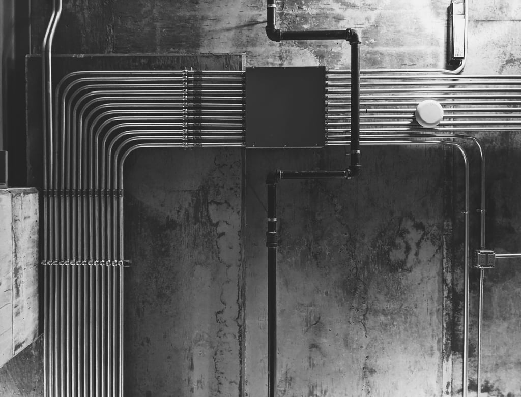 Neatly organized exposed electrical conduits on an industrial concrete wall for MEP planning.