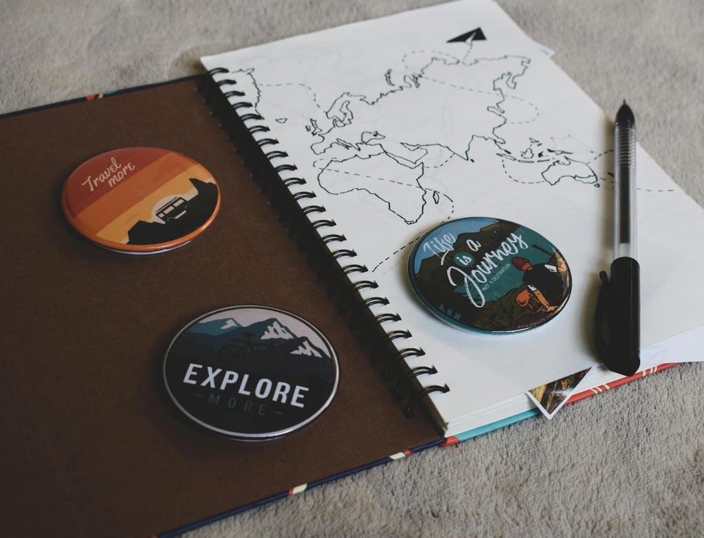 a notebook with a pen and a notebook with a map of the world