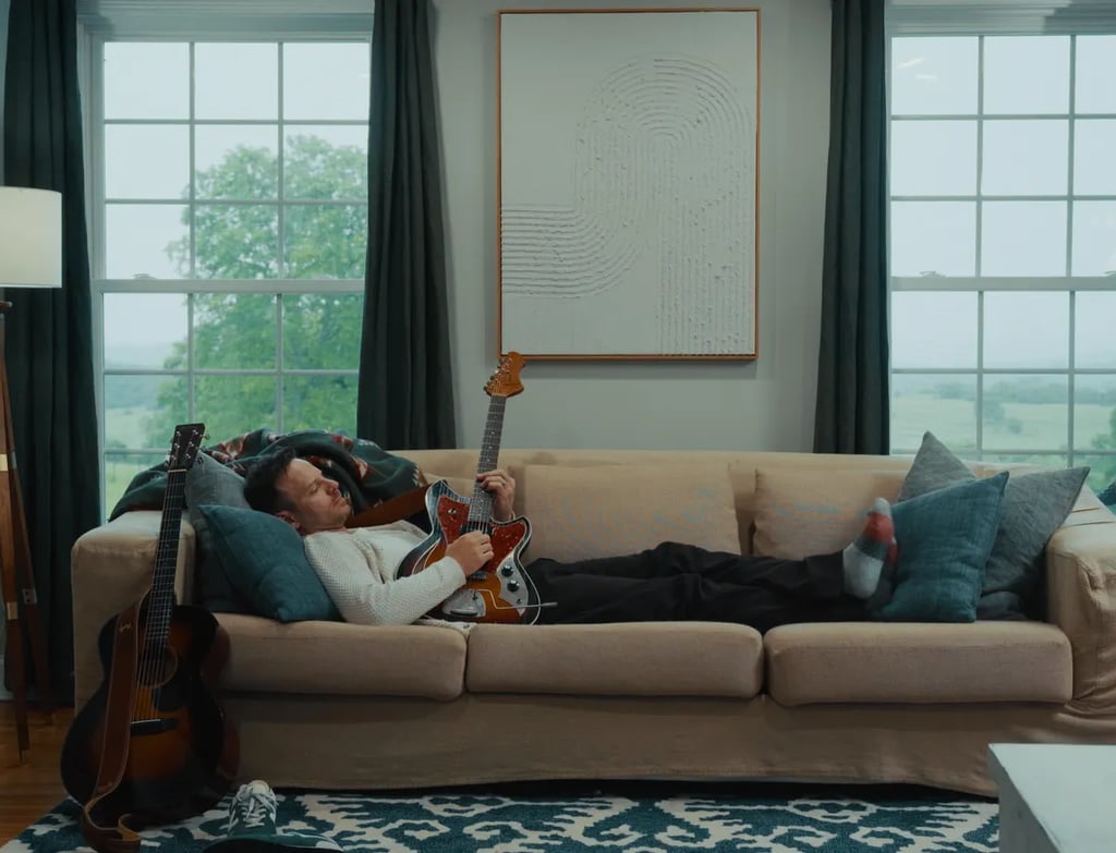 a man laying on a couch in a living room