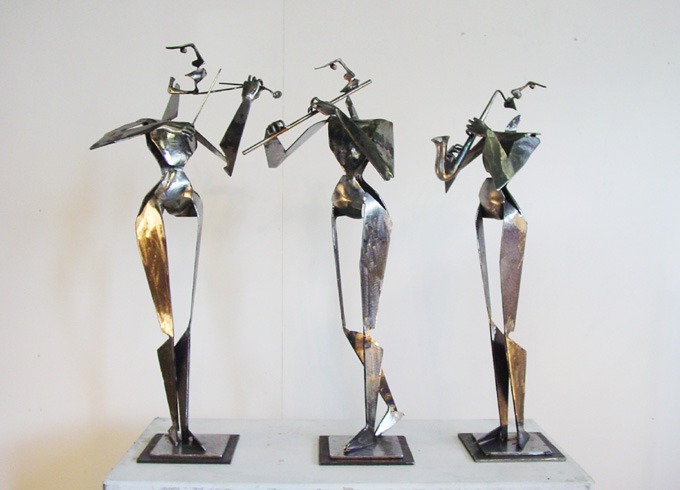 three statues of cubist musicians playing instruments