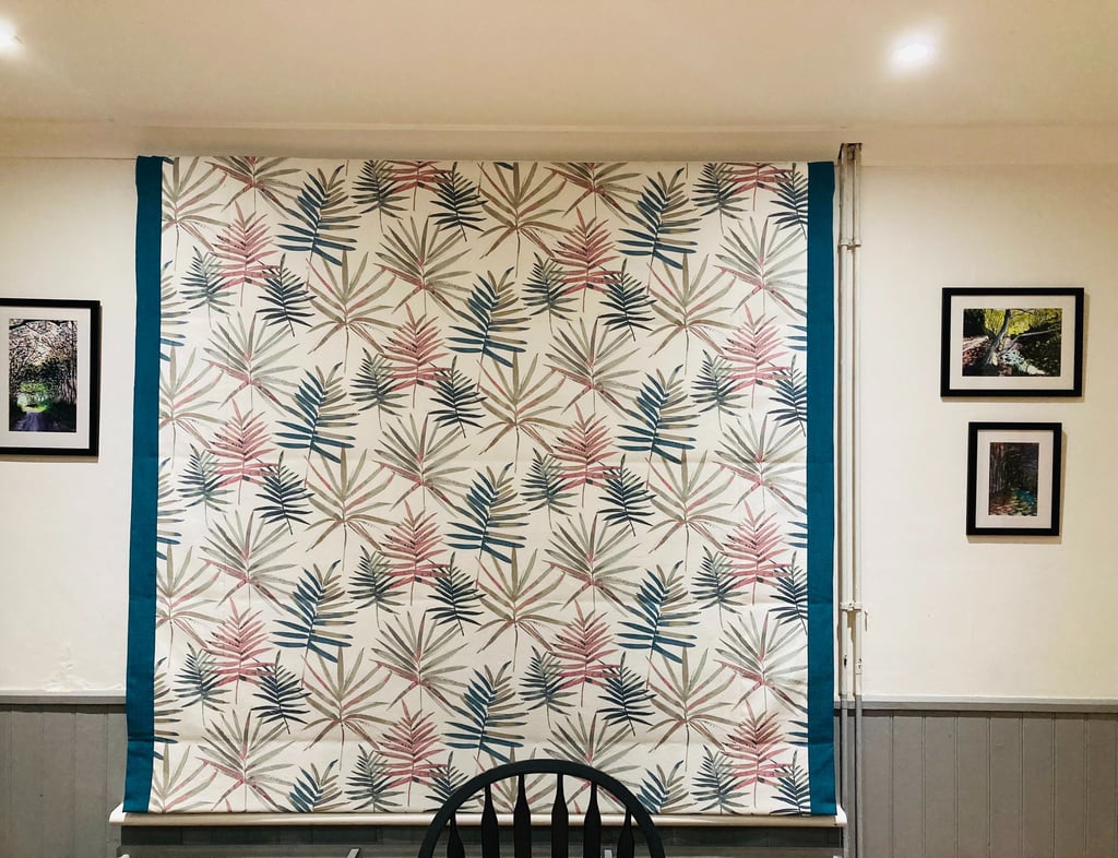 Picture of roman blind that is down that has borders both sides to emphasise one of the colours in the main fabric