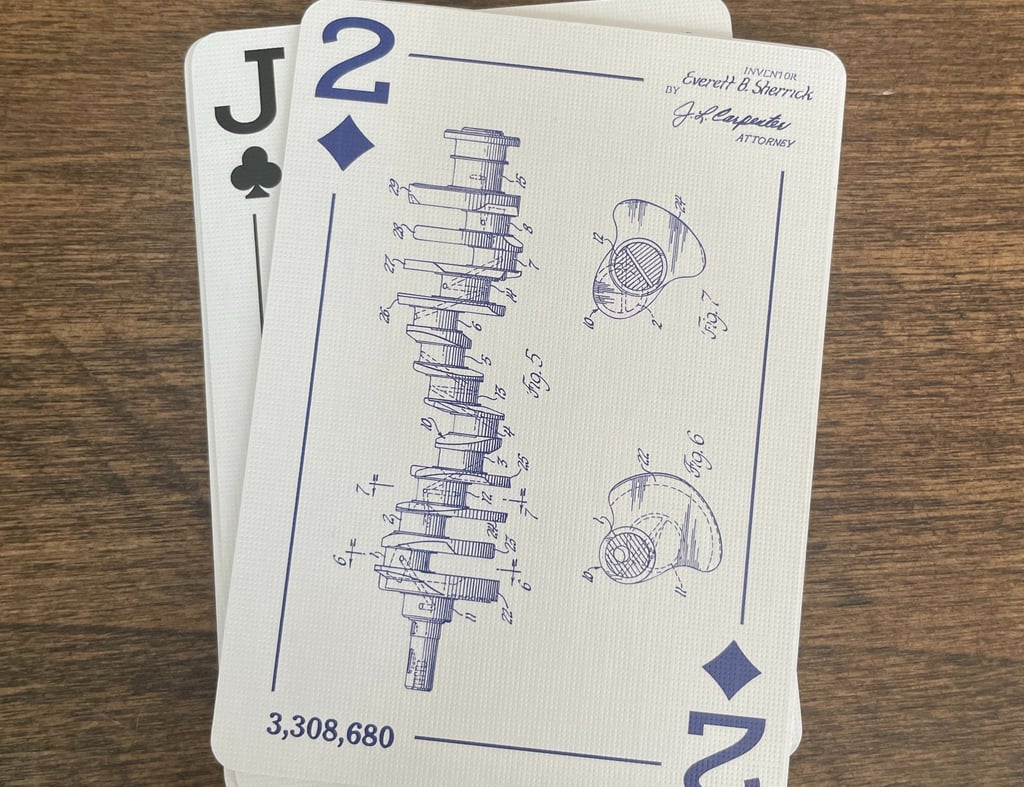 The Two of Diamonds is shown face up, with a patent drawing of a balanced crankshaft from an engine