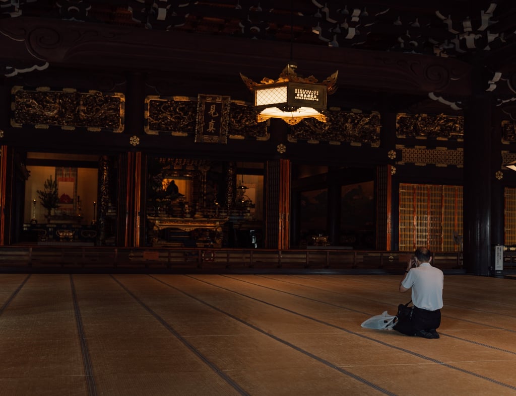 a man sitting on a floor with a skateboard