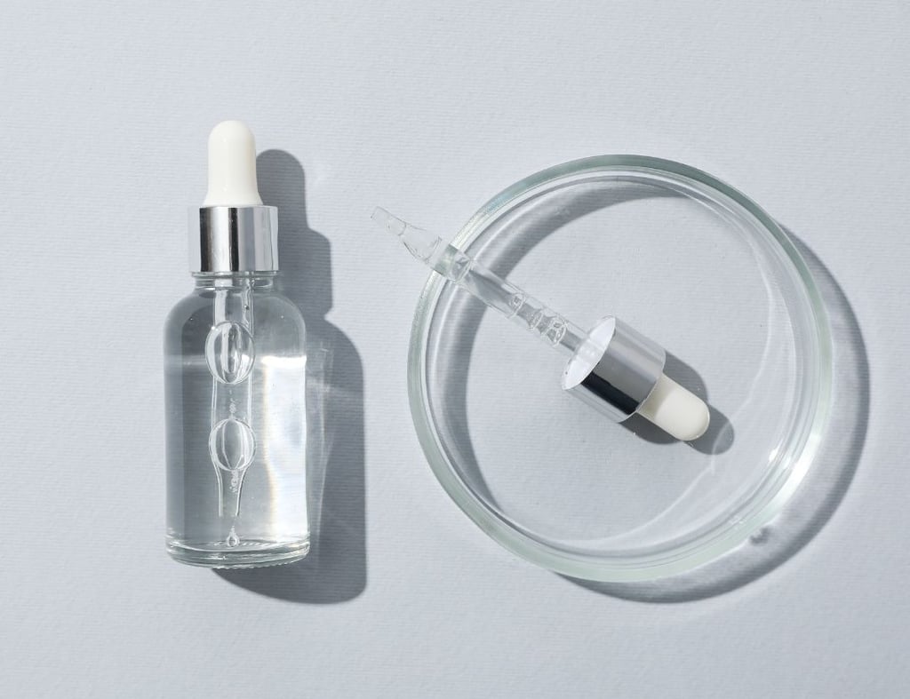 a small glass bottle of liquid with a small pill pill