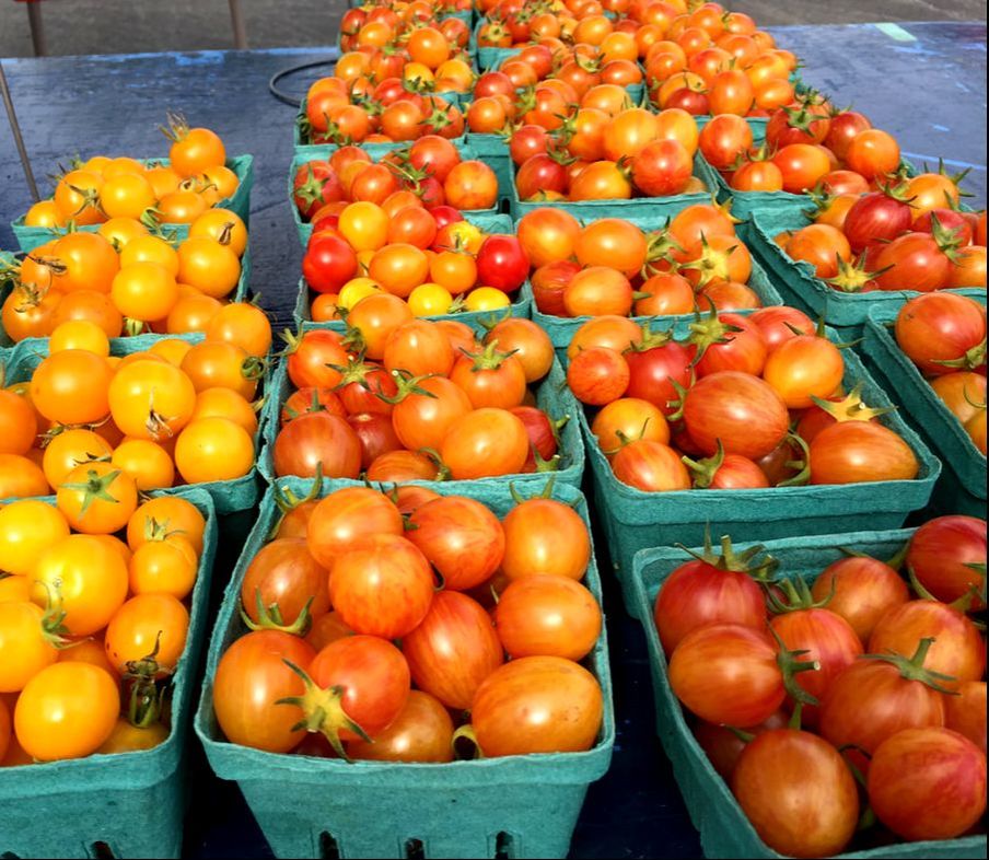 cherry tomatoes in green containers at a market