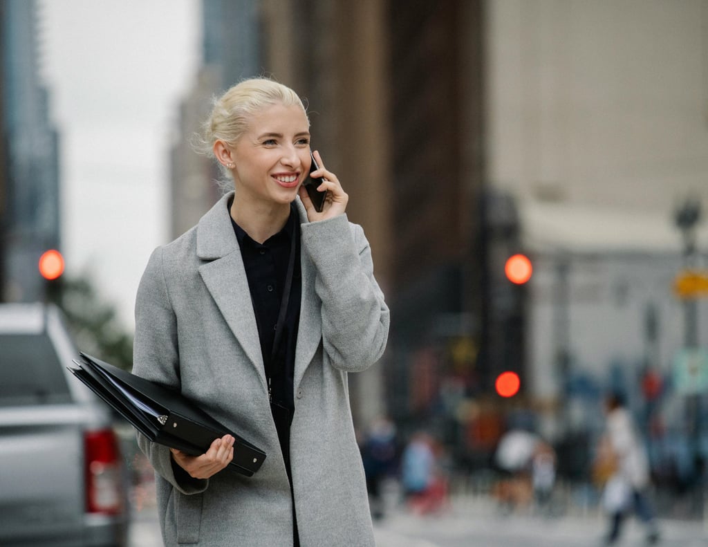 a woman in a gray coat and black pants