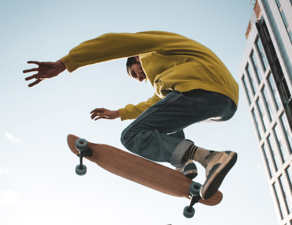 a man in a yellow shirt is doing tricks on a skateboard