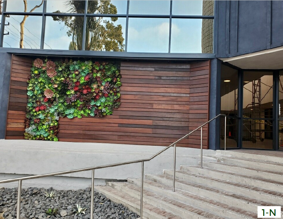 a building with a wall of plants on the side of it