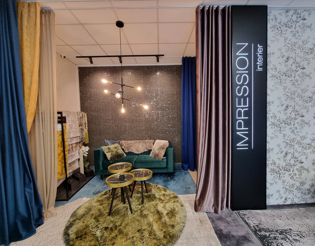 Modern living room showroom display with velvet sofa, designer lighting, and luxury curtains.