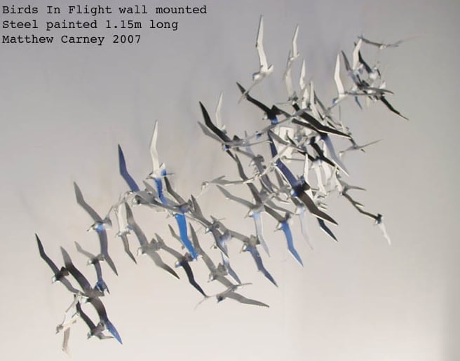 Steel sculpture of a flock of shearwaters in flight