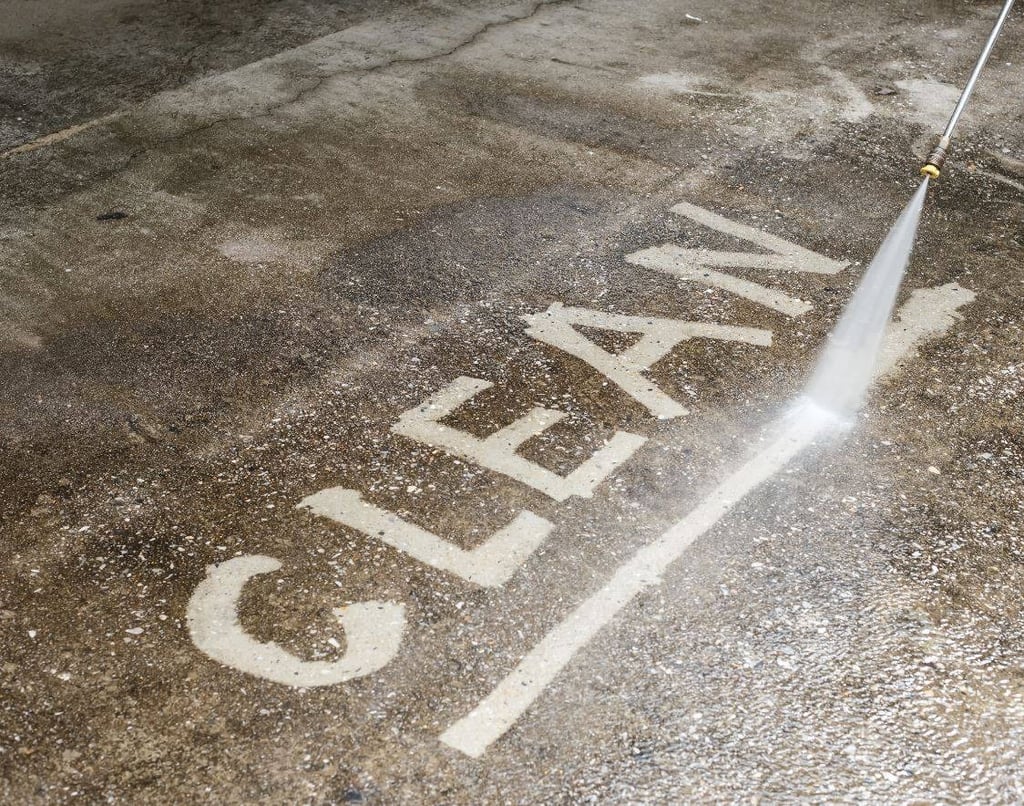 Clean written on to a concrete walk way by a pressure washing services pressure washing worker
