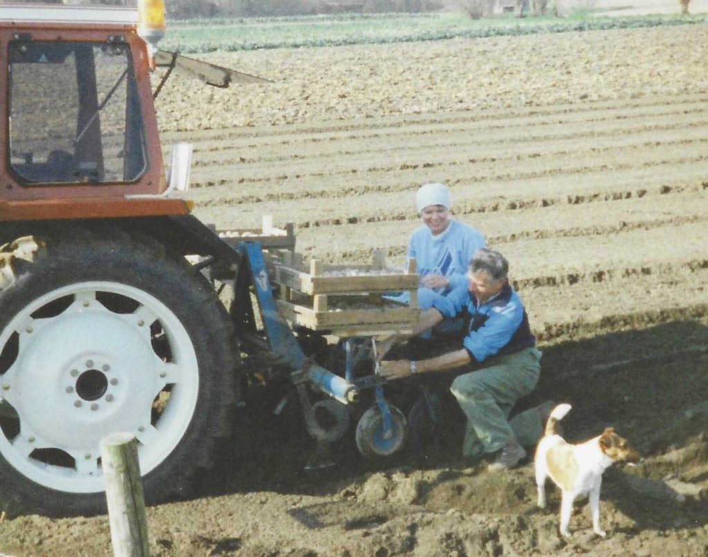 Oude foto van familie die met een tractor op het land werken bij Hoeve Dinjens in Maastricht
