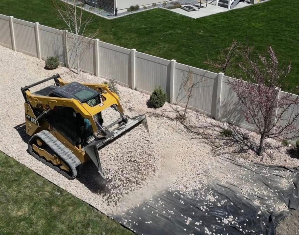 skid steer dumping landscape rock at residential home 