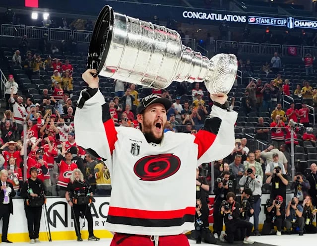 2026 Stanley Cup is held up by a Carolina Hurricanes player