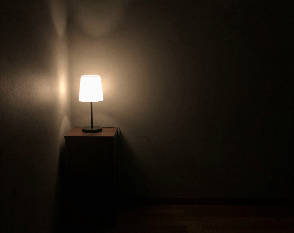 Poor lighting room with single dim light creating dull atmosphere.