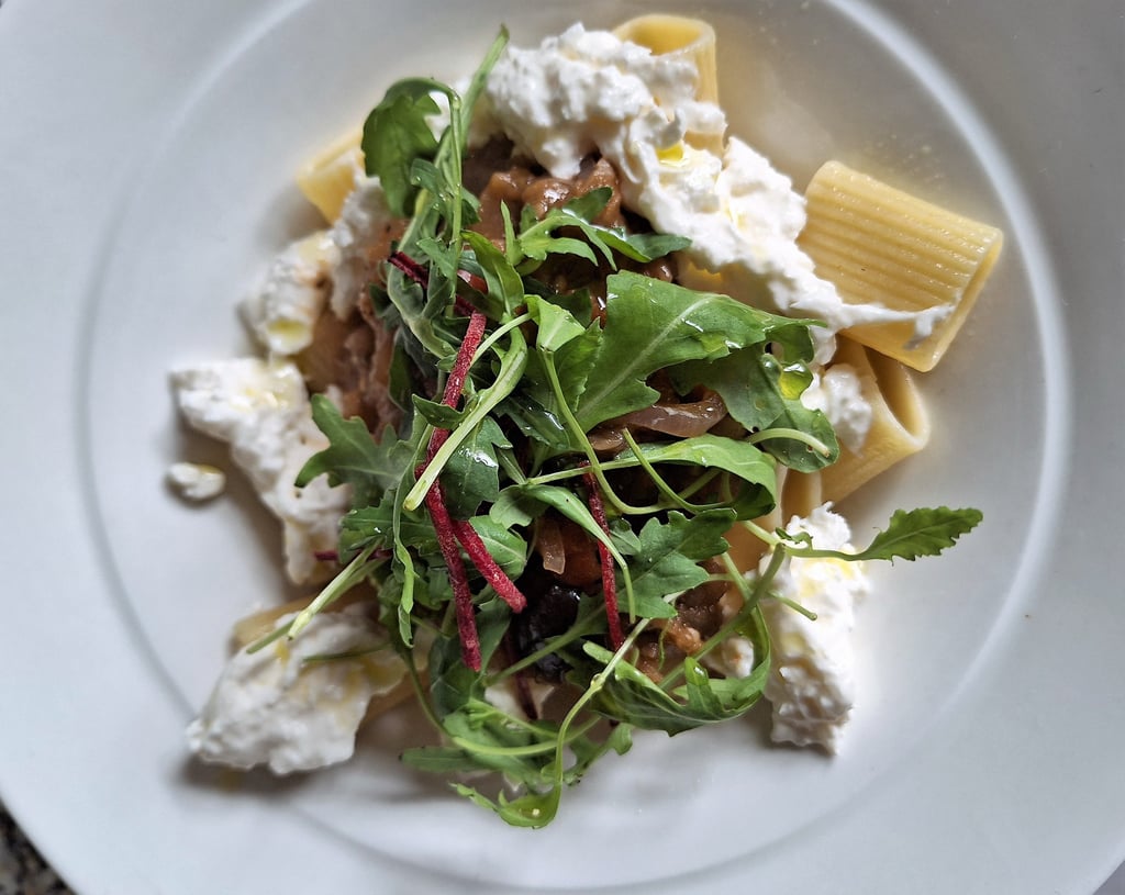 a plate of pasta with cheese and vegetables