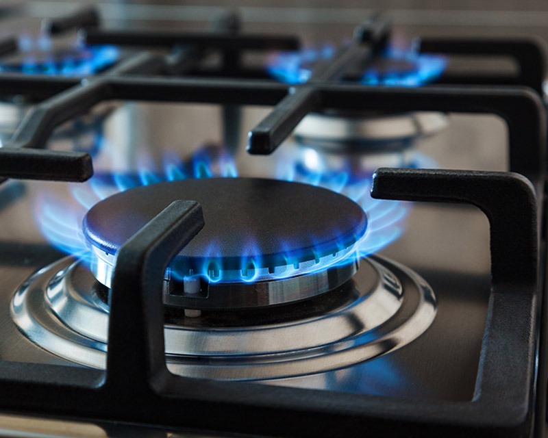 a gas stove top with blue flames on it