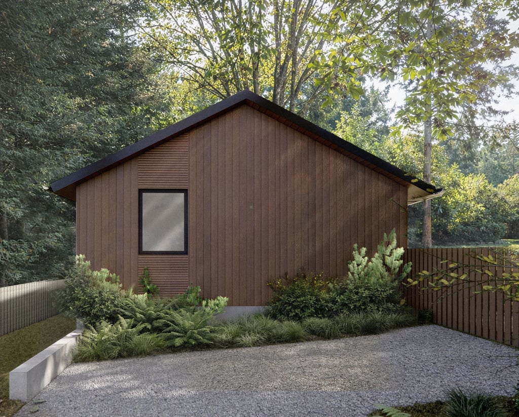 Modern wood-sided cabin with a gable roof nestled in a lush green forest setting.