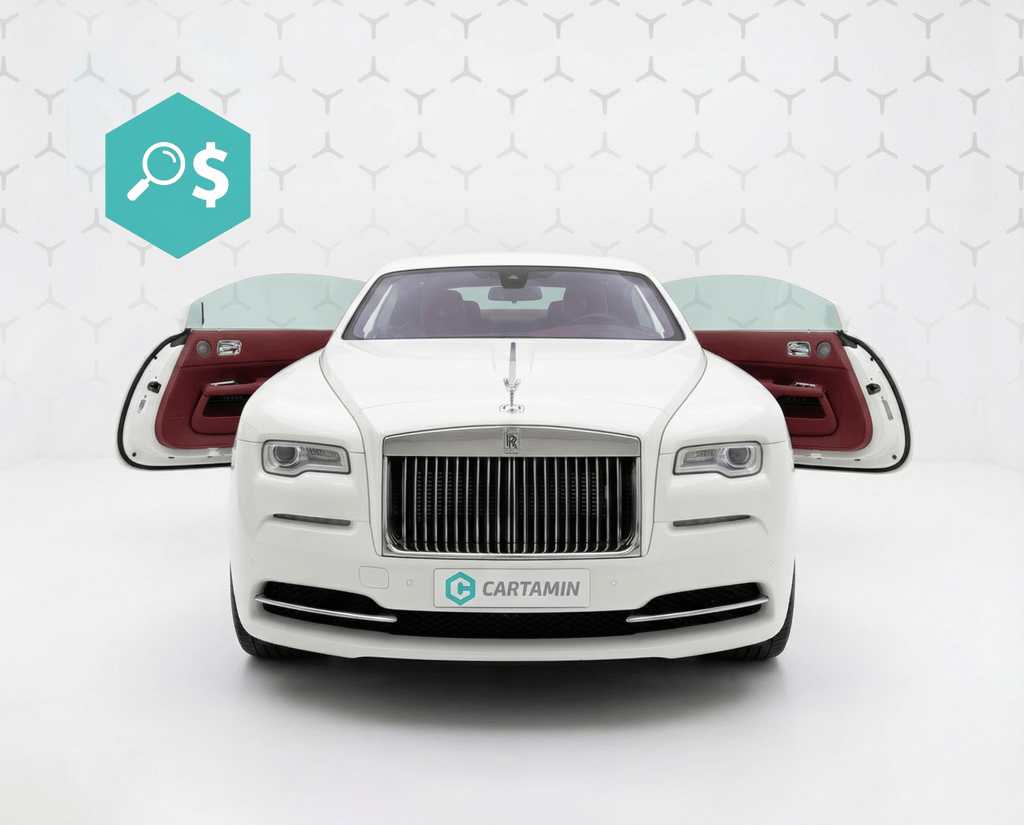 White Rolls-Royce Wraith luxury coupe with open suicide doors and red leather interior in a showroom.