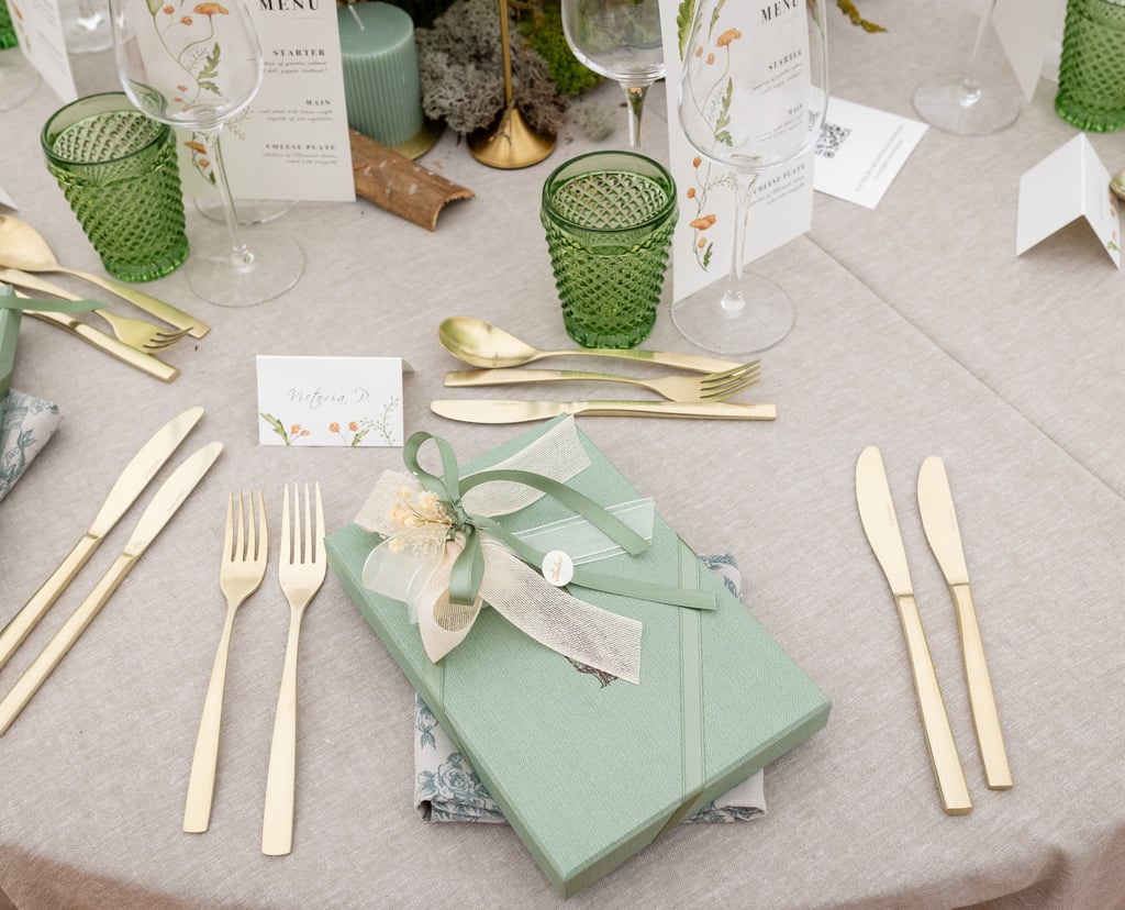 a table setting with a gift wrapped in a gift box