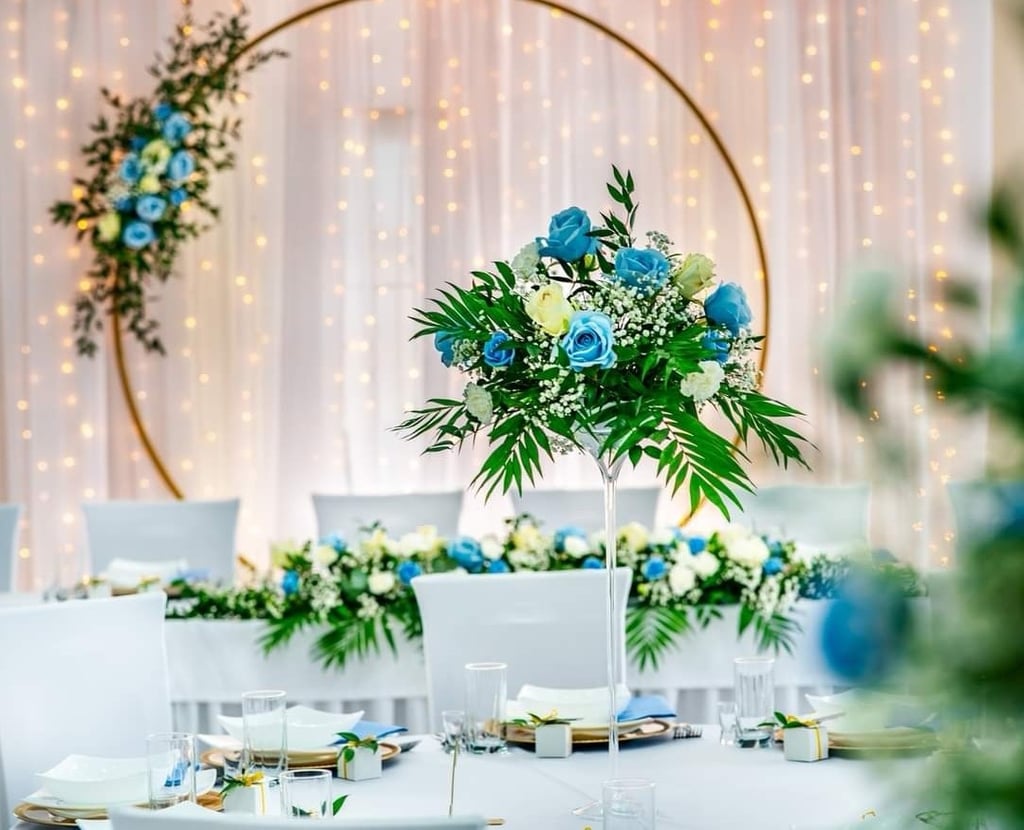 a table with a vase with flowers and a table with white chairs