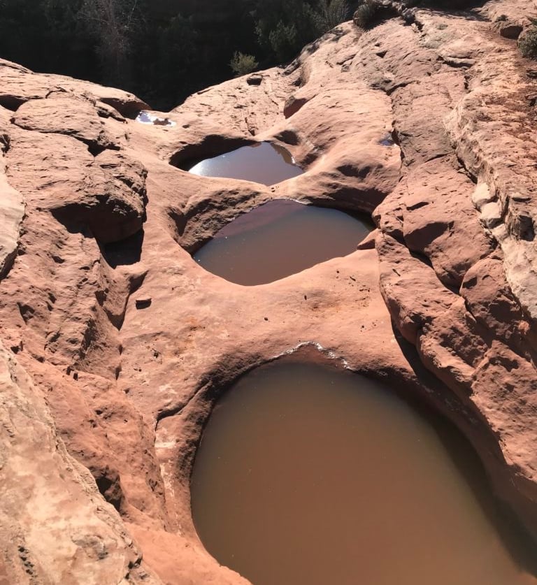 Natural desert rock pools filled with rainwater, emergency water source in arid survival environments