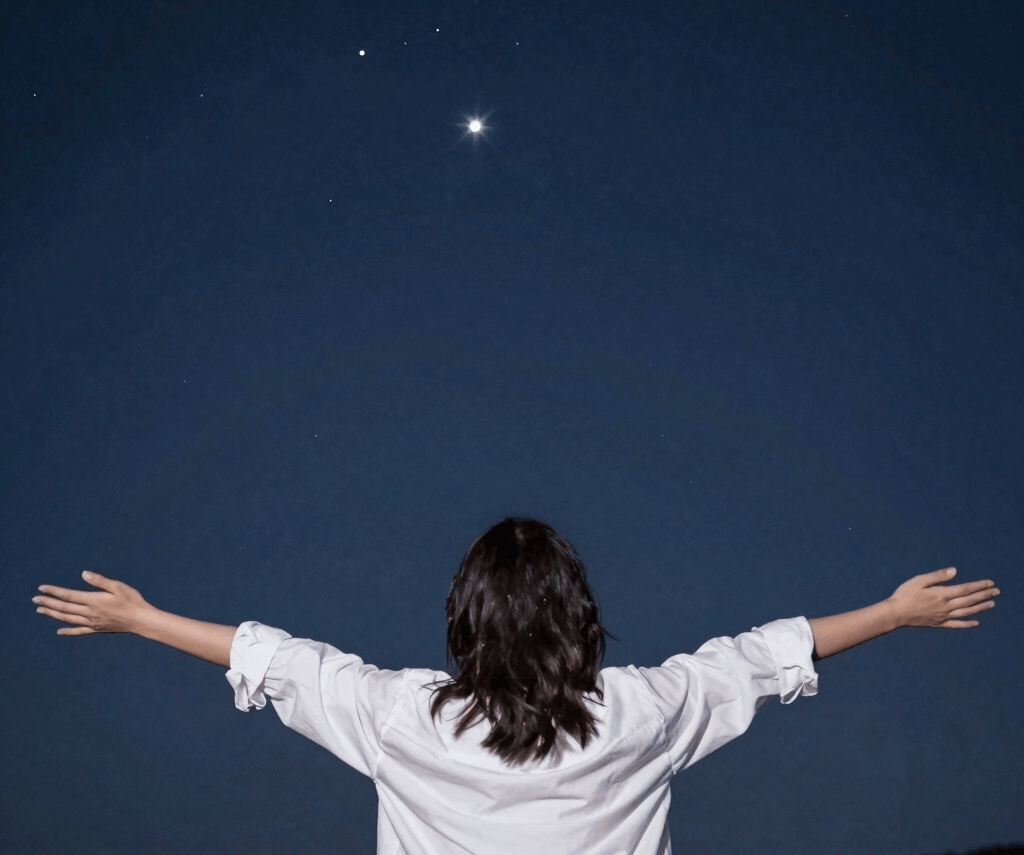 A serene astral projection scene with a person gently floating above a calm body of water under a deep indigo sky.